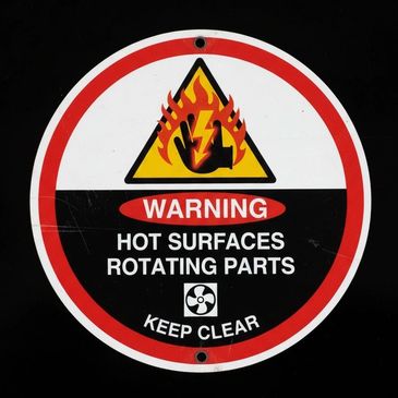 Warning sign for hot surfaces and rotating parts.