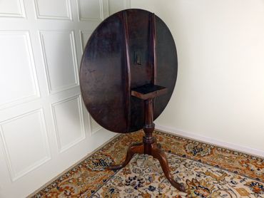 Functional tilt-top mechanism on a George III era mahogany center table, circa 1800.