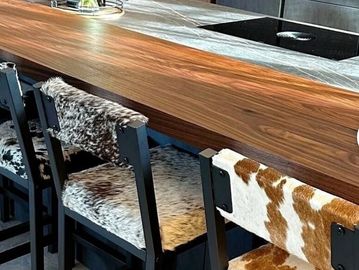 Modern kitchen bar with cowhide upholstered chairs and elegant lighting.