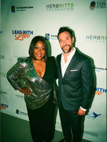 Two people posing at a charity event.