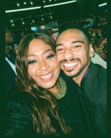 Two people smiling together at an event.