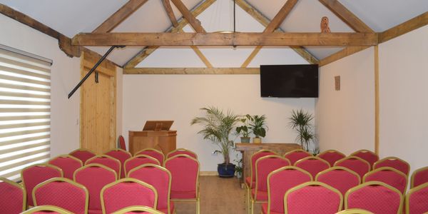 Small conference room with red chairs and wooden beams.
