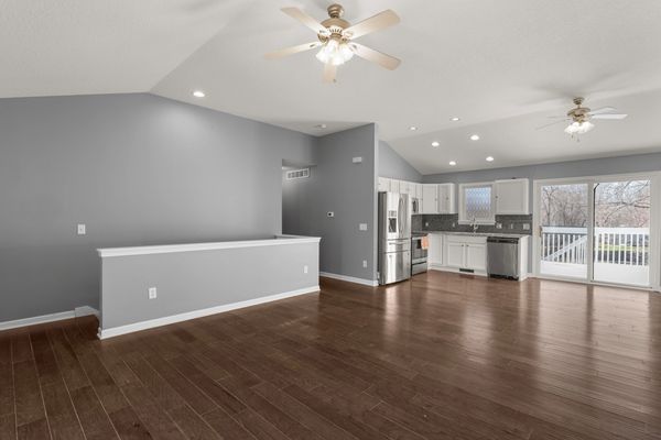 Spacious open-concept kitchen and living area with hardwood floors and ceiling fans.