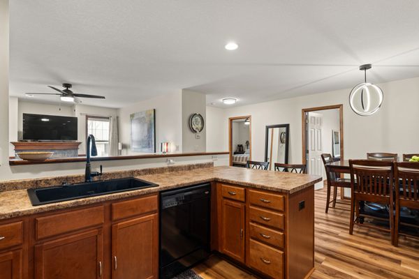 Modern kitchen with wooden cabinets and open dining area.