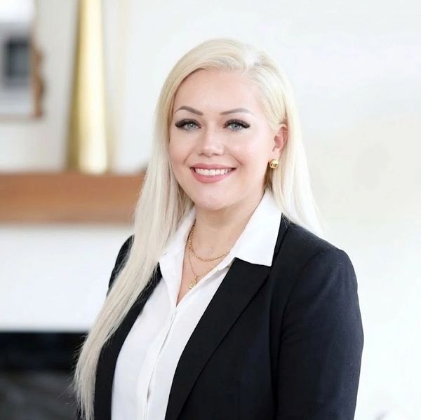 Confident woman in business attire smiling at the camera.