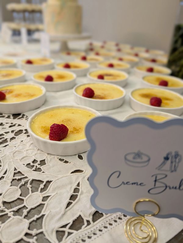 Vanilla creme brulee topped with a fresh raspberry