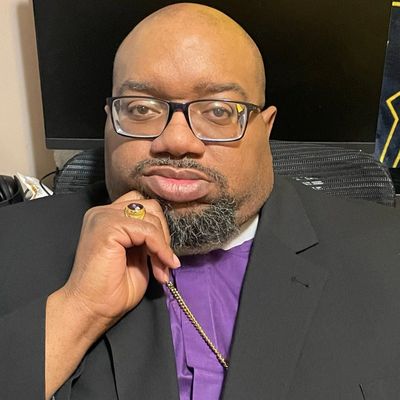 Man with glasses and a thoughtful expression in formal attire.
