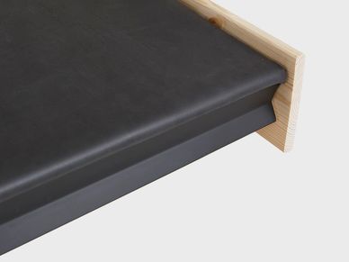 Detalle de encimera negra con borde de madera clara.