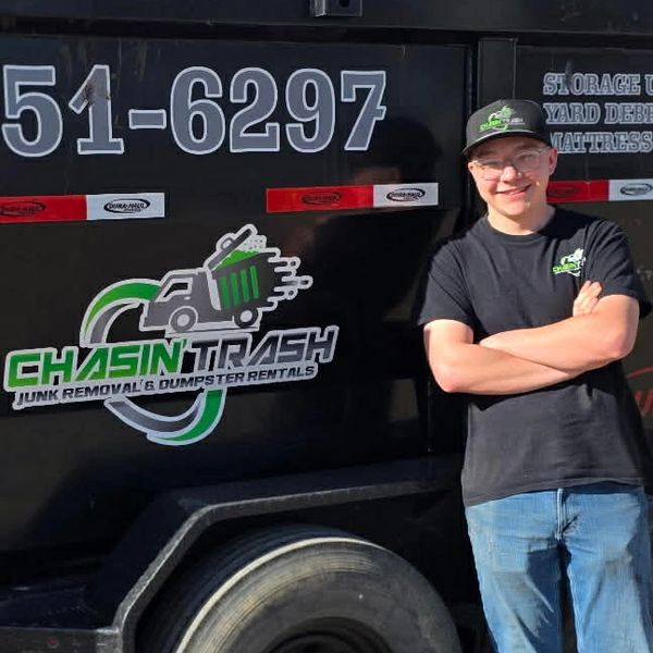 Chase from Chasin' Trash leaning against the dumpster trailer