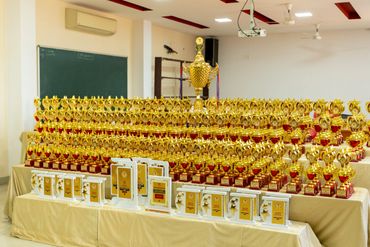 A large collection of gold trophies and awards displayed on tables.