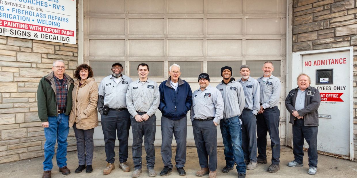 A group of people posing for a picture with a wall background