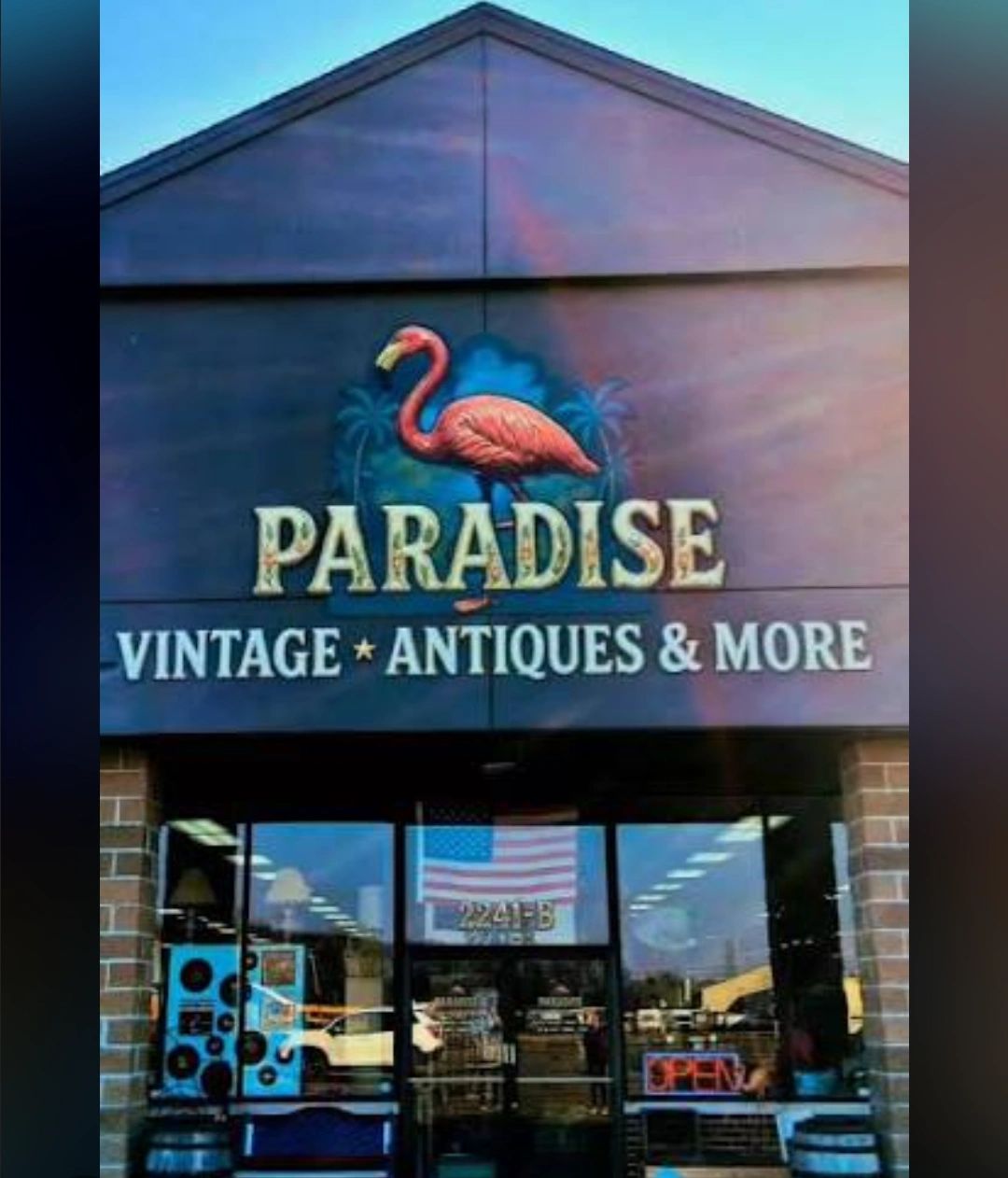 Storefront of Paradise Vintage Antiques &amp; More with flamingo logo.