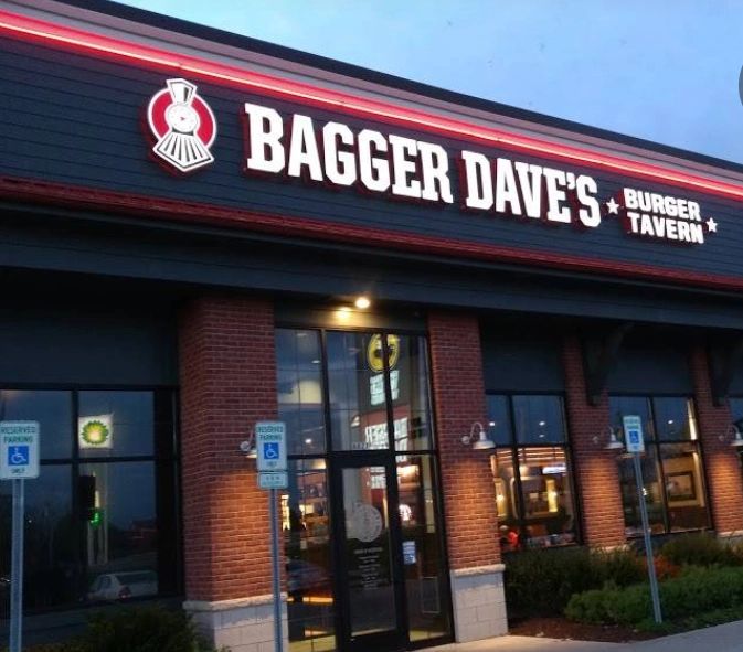 Bagger Dave's Burger Tavern exterior with illuminated signage at dusk.