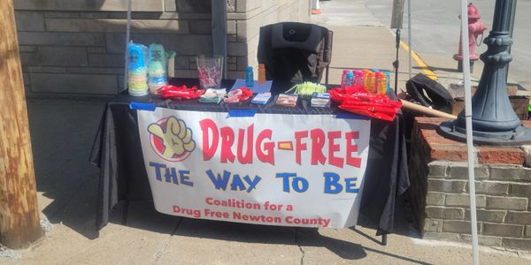 A drug-free awareness table set up with giveaways and a banner.