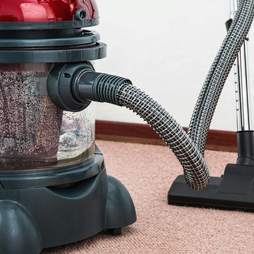 Close-up of a red wet-dry vacuum cleaner on carpet.