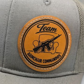 A cap with a patch showing 'Team Armchair Commandos' and a gun over an armchair.