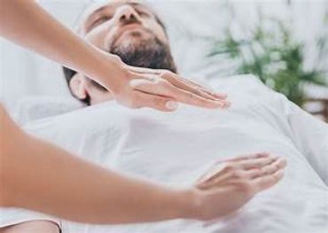 A person receiving energy healing therapy with hands near chest and abdomen.