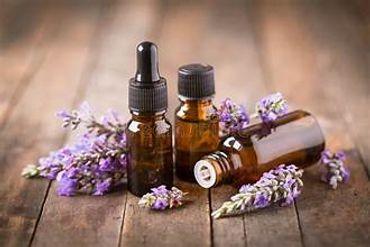 Brown glass bottles with lavender flowers on wooden surface.
