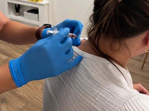 Healthcare provider administering a trigger point injection (TPI) to a patient’s shoulder for muscul