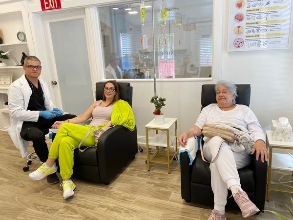 Patients seated in reclining chairs receiving IV therapy at the clinic
