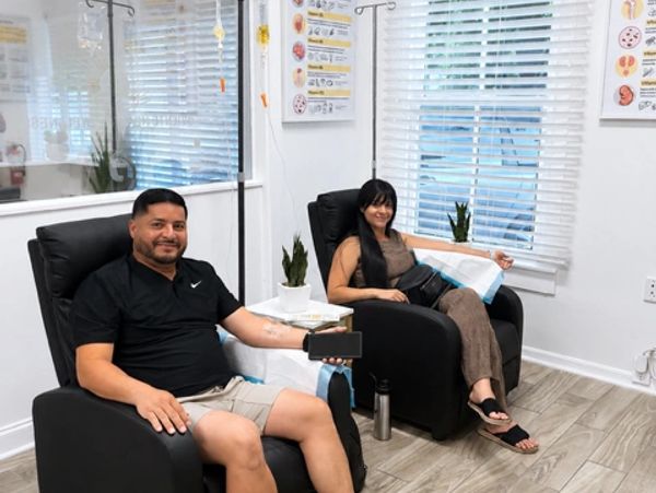 A couple receiving IV therapy together in reclining treatment chairs at Oriente Health & Wellness.