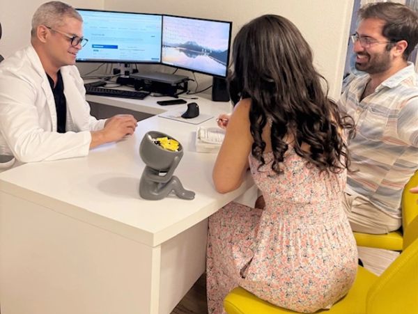 Provider reviewing test results on-screen with a patient couple