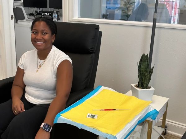 A smiling patient seated in a treatment chair receiving vitamin and nutrient support care