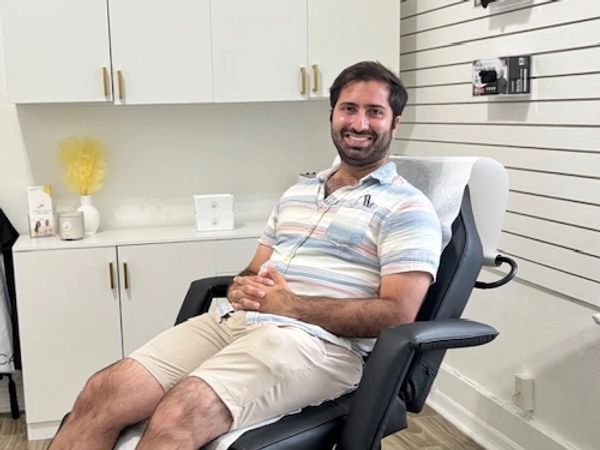 A smiling patient seated comfortably in a treatment chair during a wellness visit