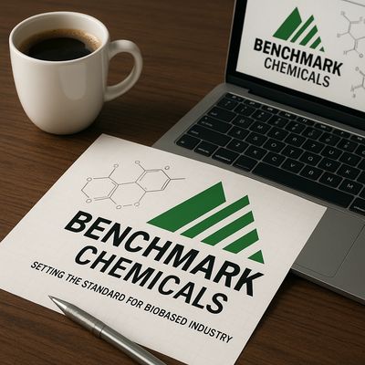 Benchmark Chemicals logo on paper beside laptop and coffee cup, symbolizing the brand story.