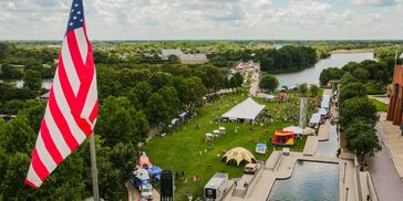 Aerial view of a park with an American flag and a river.
