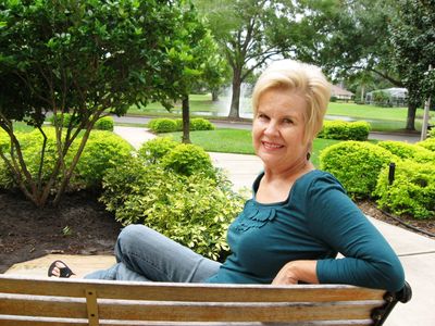 Smiling woman sitting on a park bench.