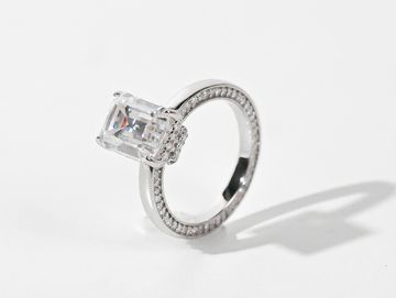 Elegant silver ring with a large rectangular diamond and smaller stones on the band.