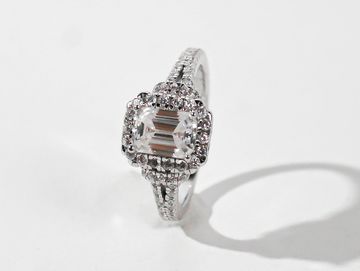 Elegant silver ring with a large square-cut central diamond and smaller diamonds on the band.