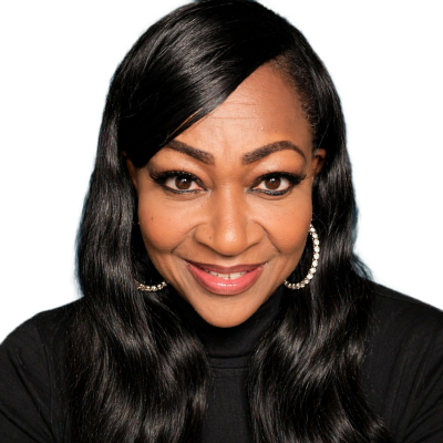 Smiling woman with long black hair and hoop earrings.