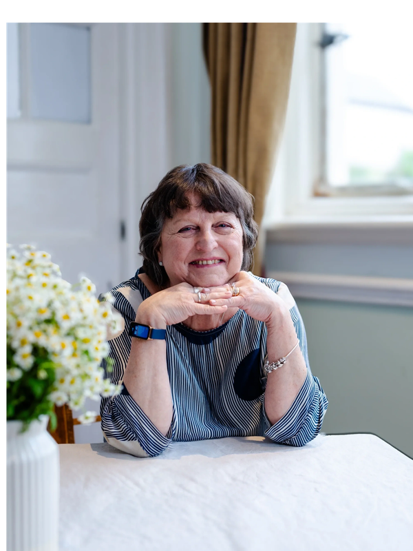 Picture of Sharon sitting at a desk with window behind and smiling