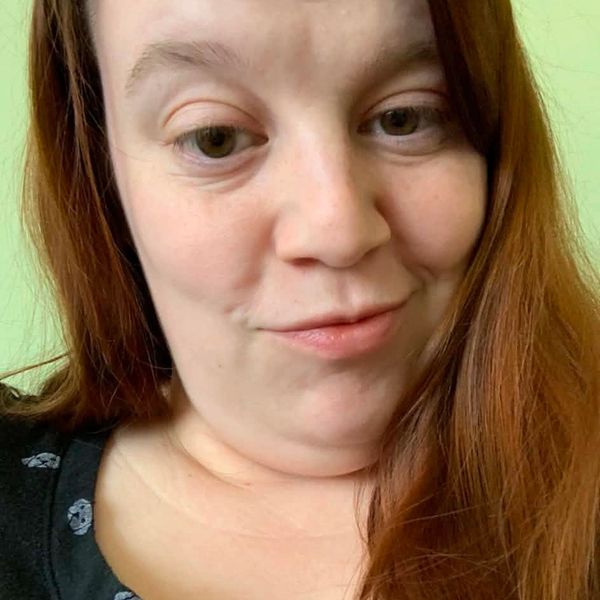 Close-up of a woman with red hair making a playful face.