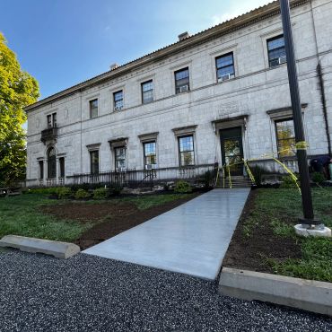 Historic building with new concrete pathway leading to the entrance.