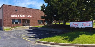 Geneva Body Shop building and parking lot under blue sky.