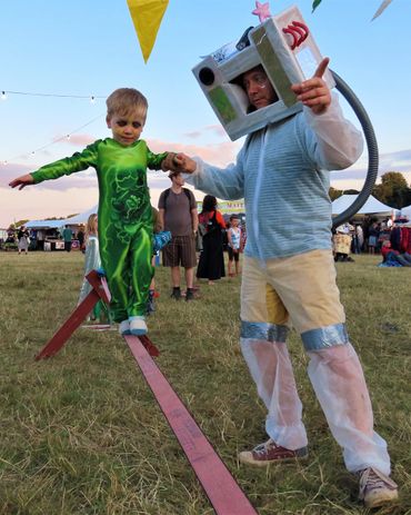 a father and son dressed in fancy dress whilst slacklining