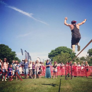 Members of the public watching a trickliner giving a performance at a country show