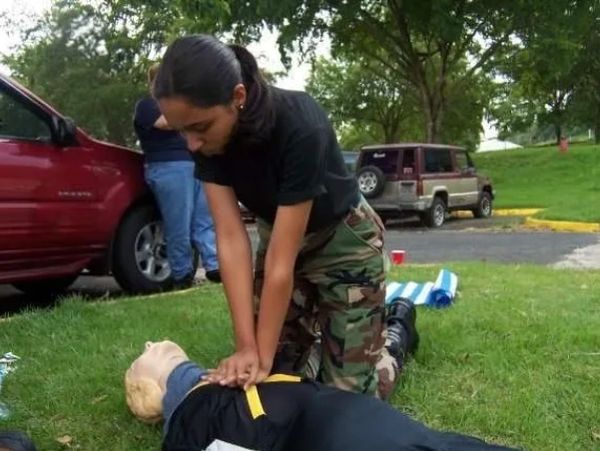 Teenager performing CPR on manikin.