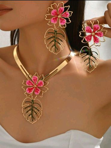 Woman in gold earring with matching necklace, smiling warmly.

