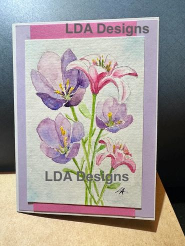 Watercolor painting of pink and purple flowers.