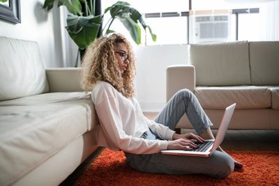 A Woman With Wavy Blond Hair Looking At Laptop