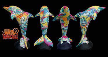 Colorful dolphin sculptures painted with vibrant cartoon designs on black stands.