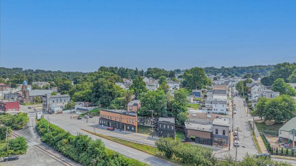 A small town with streets lined by trees and buildings under a clear blue sky.