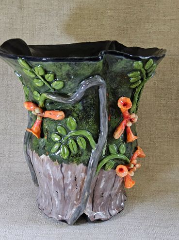 Decorative ceramic vase with tree and flower design.