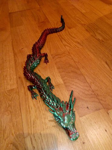 This is a shiny red and green dragon that glimmers in the light as if it had real scales.