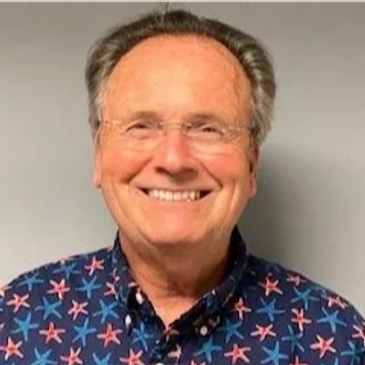 Smiling elderly man in a starfish-patterned shirt.