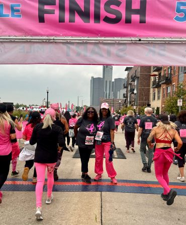 Participants crossing the finish line at a breast cancer awareness run.